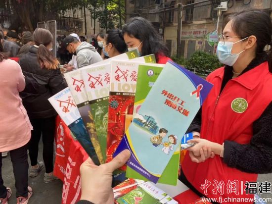 巾帼志愿者向社区居民发放宣传手册。