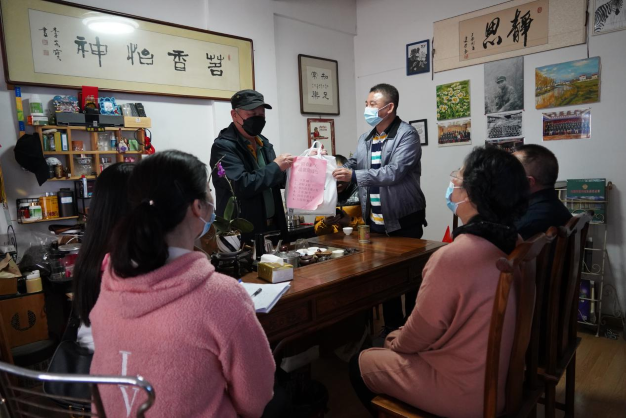 图为志愿者们给澳门同胞李先生送上防疫用品。1.png