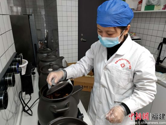 图为工作人员正在用专业设备熬制药汤。林玲 摄
