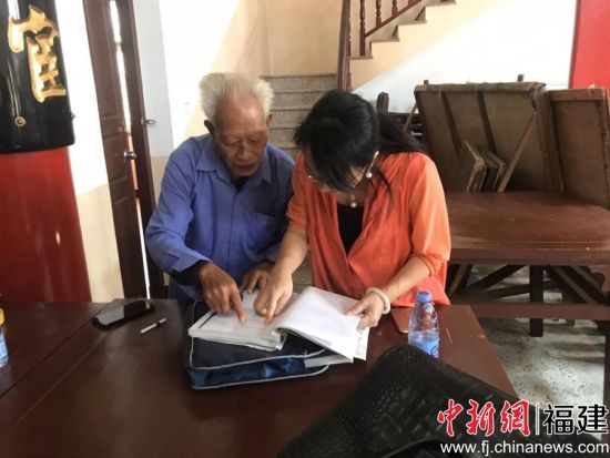 　　图为王平跟平潭五福堂族人查找五福文化资料
