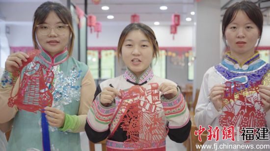 图为少数民族学生包月饼共度中秋佳节。